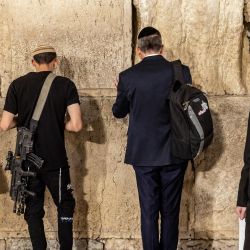 Un hombre judío que porta un arma representa una oración, entre otras, en el Muro Occidental en la Ciudad Vieja de Jerusalén, en medio de las batallas en curso entre Israel y el movimiento palestino Hamas. | Foto:FADEL SENNA / AFP