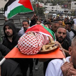 Los dolientes cargan el cuerpo de Issa al-Qadi, un palestino de 66 años que, según informes, fue asesinado a tiros mientras conducía su taxi durante una operación militar de las fuerzas israelíes ese mismo día, antes de su entierro durante el funeral en Hebrón, en la Cisjordania ocupada. | Foto:HAZEM BADER / AFP