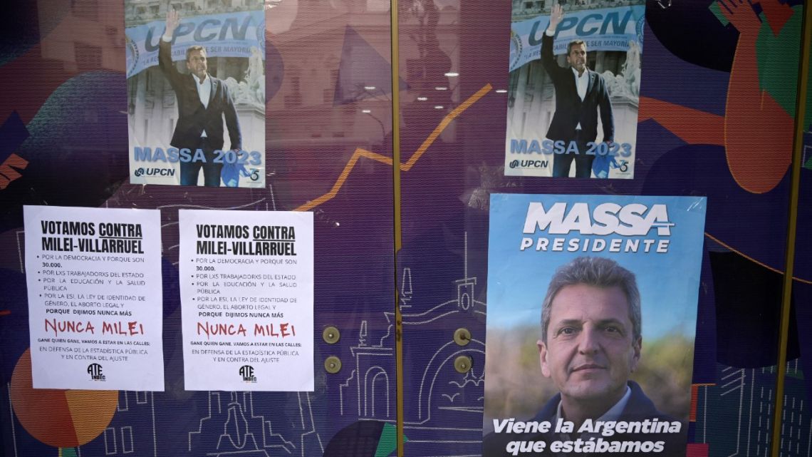 People pass by the INDEC national statistics bureau displaying political propaganda for Economy Minister and presidential candidate for Union por la Patria party Sergio Massa in Buenos Aires on November 13, 2023.