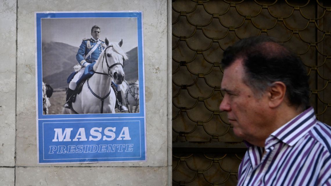 A mna walks past a poster depicting Economy Minister Sergio Massa, presidential candidate for the Unión por la Patria party, on a horse, in Buenos Aires on November 7, 2023. 