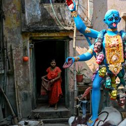 Una mujer hace un gesto junto al ídolo de la diosa hindú Kali durante la celebración de Kali Puja, en Calcuta, India. | Foto:ARUN SANKAR / AFP