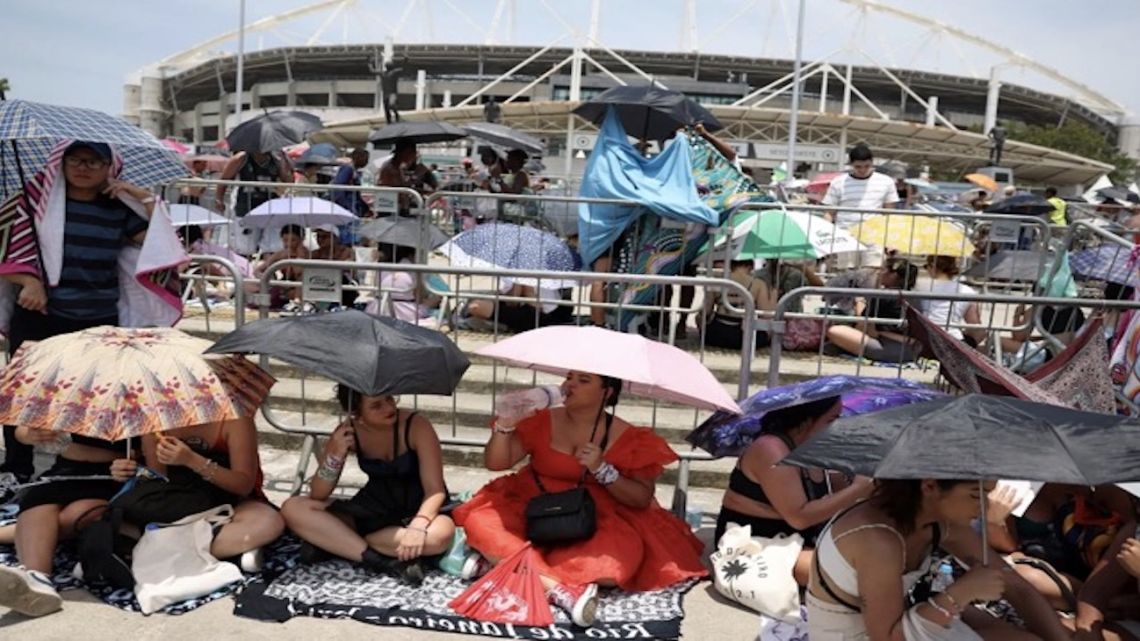 Taylor Swift fans queue outside of Nilton Santos Stadium in extreme heat.