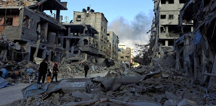 Los palestinos caminan entre escombros en Beit Lahia tras el bombardeo israelí, en medio de las batallas en curso entre Israel y el movimiento palestino Hamas.