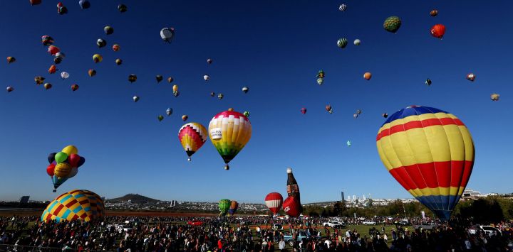 Un grupo de personas observa cómo se elevan los globos aerostáticos durante el 21º Festival Internacional de Globos Aerostáticos en León, estado de Guanajuato, México.