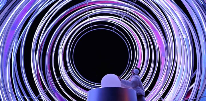 Una mujer mira una instalación de luz al aire libre mientras visita el Festival Internacional de la Luz Chaoyang de Beijing en un parque.