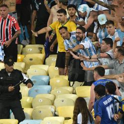 La policía brasileña se enfrenta a fanáticos de Argentina antes del inicio del partido de fútbol de clasificación sudamericano para la Copa Mundial de la FIFA 2026 entre Brasil y Argentina en el estadio Maracaná de Río de Janeiro, Brasil. | Foto:CARL DE SOUZA / AFP