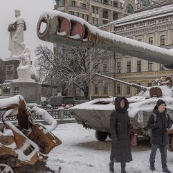 Peatones pasan junto a vehículos militares rusos destruidos cubiertos de nieve frente al Monasterio de las Cúpulas Doradas de San Miguel, en el centro de Kiev, en medio de la invasión rusa de Ucrania. | Foto:Román Pilipey / AFP