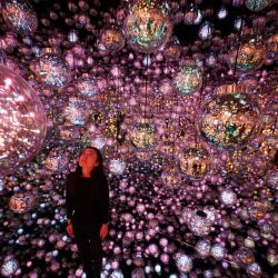 Un miembro del personal se encuentra frente a la obra de arte interactiva "Bubble Universe" durante una vista previa para los medios del teamLab Borderless: MORI Building Digital Art Museum en Azabudai Hills en Tokio. | Foto:Kazuhiro Nogi / AFP