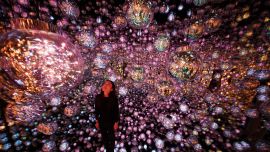 Un miembro del personal se encuentra frente a la obra de arte interactiva "Bubble Universe" durante una vista previa para los medios del teamLab Borderless: MORI Building Digital Art Museum en Azabudai Hills en Tokio.