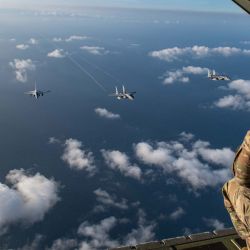 En esta fotografía tomada y recibida a través de la embajada de EE. UU. en Manila, se muestra a un personal de la fuerza aérea de EE. UU. observando dos FA-50 de la Fuerza Aérea de Filipinas volando junto a dos F-15C Eagle de la Fuerza Aérea de EE. UU. sobre el Mar de China Meridional durante las patrullas marítimas y aéreas conjuntas. | Foto:Class Alexis Redin / US AIR FORCE / AFP