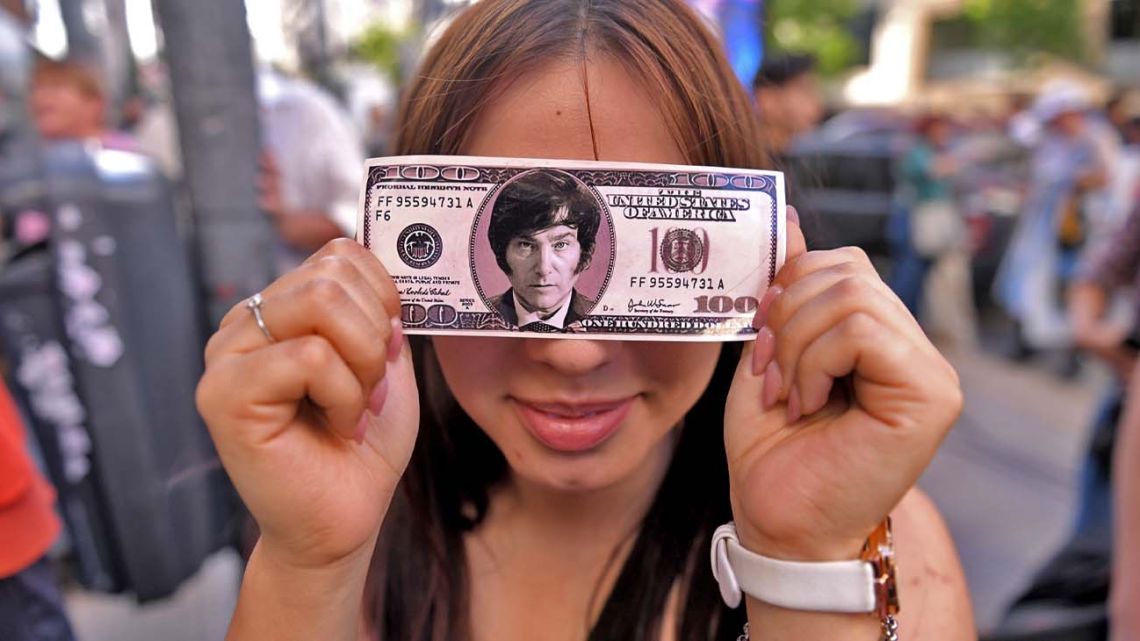 A supporter of Javier Milei poses for a photograph withy a fake US$100-dollar bill with the libertarian's face on it.