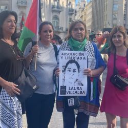 Myriam Villalba, holding the Palestinian flag, stands with other activists calling to end violence against women.