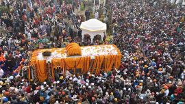 Los devotos sikh se reúnen alrededor de un autobús que transporta el Guru Granth Sahib (libro sagrado sikh) durante una procesión religiosa con motivo del aniversario del nacimiento de Guru Nanak Dev. Foto de Arif ALI/AFP
