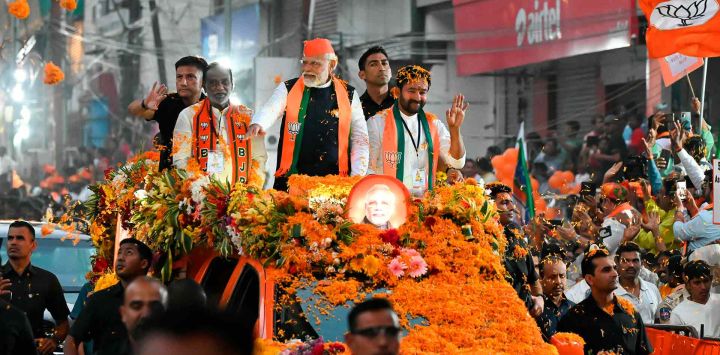 El primer ministro de la India, Narendra Modi, saluda a sus seguidores como parte de la campaña electoral del Partido Bharatiya Janata (BJP) antes de las elecciones a la asamblea estatal de Telangana, en Hyderabad. Foto de Noah SEELAM / AFP 