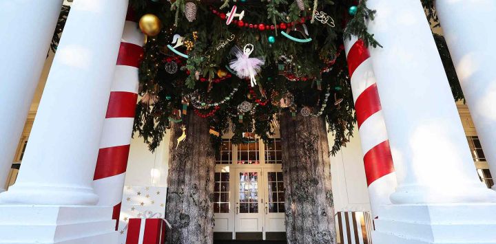 Un pequeño bosque de ramas verdes frescas y adornos navideños está suspendido del techo del Pórtico Este de la Casa Blanca, en Washington, DC. Foto de Kevin Dietsch / AFP