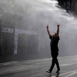 Un estudiante es rociado con cañones de agua por policías antidisturbios durante una marcha contra el proyecto de nueva constitución en Santiago. Foto de Javier TORRES/AFP | Foto:AFP