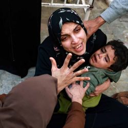 Una mujer que sostiene a un niño llora a su bebé muerta en un ataque israelí en Rafah, en el sur de la Franja de Gaza, mientras espera recibir el cuerpo para el entierro. Foto de MOHAMMED ABED / AFP | Foto:AFP