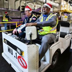 Los trabajadores postales con gorros de Papá Noel conducen por las instalaciones durante una gira de prensa organizada por el Servicio Postal de EE. UU. Foto de Frederic J. BROWN / AFP | Foto:AFP