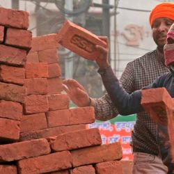 Los trabajadores descargan ladrillos de un remolque en una obra de construcción en Amritsar. Foto de Narinder NANU / AFP | Foto:AFP