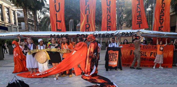 Activistas protestan contra los combustibles fósiles al margen de la cumbre climática de las Naciones Unidas COP28 en Dubai. Foto de Karim SAHIB / AFP