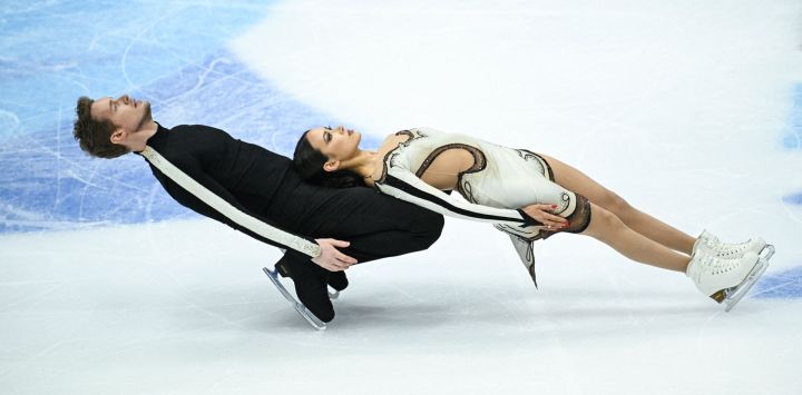 Los estadounidenses Madison Chock y Evan Bates compiten en el evento de patinaje libre sobre hielo durante la final del Gran Premio ISU de patinaje artístico en Beijing.
