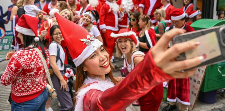 Una mujer disfrazada de Papá Noel se toma una selfie durante la SantaCon anual en Hong Kong.