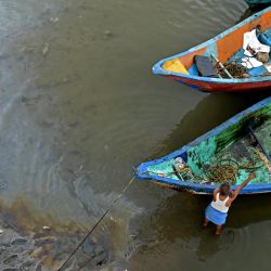 Se ven barcos pesqueros amarrados cerca del petróleo derramado sobre el remanso del arroyo Ennore después del ciclón Michaung, en las afueras de Chennai, India. | Foto:R. Satish Babu / AFP