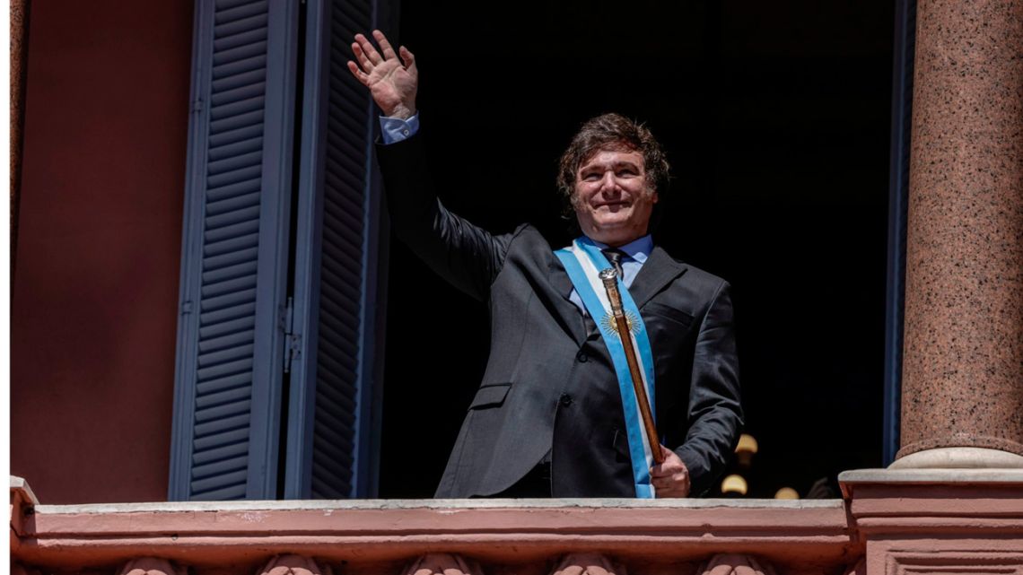 Javier Milei waves to supporters from the balcony of the Casa Rosada after his inauguration as president.