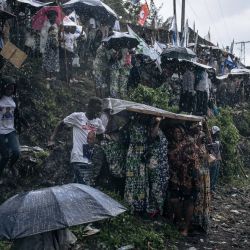 Los partidarios del presidente en ejercicio, el presidente Felix Tshisekedi, se refugian de la lluvia antes de su llegada para un mitin de campaña en Goma, capital de la provincia de Kivu del Norte, al este de la República Democrática del Congo. | Foto:ALEXIS HUGUET / AFP