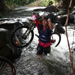 Una competidora participa en una carrera de bicicleta de montaña en la isla caribeña francesa de Martinica, como parte del "Raid des Alizes", una competición multideportiva exclusivamente femenina. | Foto:ANNE-CHRISTINE POUJOULAT / AFP