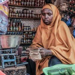 Una mujer somalí cuenta billetes de chelines somalíes en su puesto en el mercado de Hamarweyne en Mogadiscio. | Foto:Hassan Ali Elmi / AFP