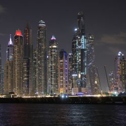 Un barco navega en un paseo nocturno en el puerto deportivo de Dubái con vistas al horizonte de los Emiratos del Golfo. | Foto:GIUSEPPE CACACE / AFP