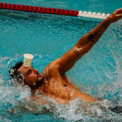 El nadador francés Florent Manaudou nada durante una sesión de entrenamiento con niños en la piscina recientemente renovada de la rue de Pontoise en París. | Foto:DIMITAR DILKOFF / AFP