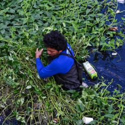 Un hombre recoge basura durante una limpieza a lo largo de un río en Paranaque City, Metro Manila, Filipinas. | Foto:JAM STA ROSA / AFP