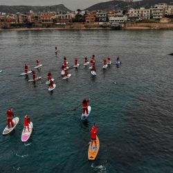 Una vista aérea muestra a personas vestidas con trajes de Papá Noel montando remos en el mar Mediterráneo, en la ciudad costera de Batroun, en el norte del Líbano. | Foto:IBRAHIM CHALHOUB / AFP
