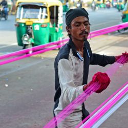 Un hombre aplica capas de polvo de vidrio a las cuerdas de una cometa antes del festival hindú 'Uttarayan' en Ahmedabad, India. | Foto:SAM PANTHAKY / AFP
