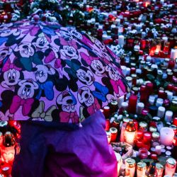Un niño coloca una vela en un monumento improvisado para las víctimas del tiroteo en la Universidad Carolina, en las afueras de la Universidad Carolina en el centro de Praga, durante un día de luto nacional. | Foto:Michal Cizek / AFP