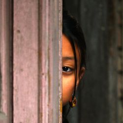 Una niña observa a los miembros de la comunidad étnica nepalí Newar participar en las celebraciones del 'Día Jyapu' que marca el final de la temporada de cosecha, en Katmandú, Nepal. | Foto:PRAKASH MATHEMA / AFP