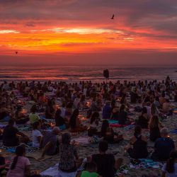 La gente asiste a una clase masiva de yoga durante el evento "Yoga al amanecer", en la playa Recreio dos Bandeirantes en Río de Janeiro, Brasil. | Foto:TERCIO TEIXEIRA / AFP