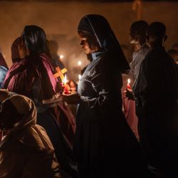 Los fieles de la Misión de la Iglesia Africana Legio María se reúnen para orar durante la misa en una iglesia cerca de Ugunja, Kenia. | Foto:LUIS TATO/AFP