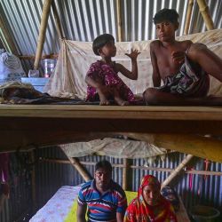 En esta fotografía miembros de una familia posan para fotografías mientras están sentados dentro de un refugio modular móvil "Khudi Bari" o "casa pequeña" en Char Shildaha. Un arquitecto galardonado de Bangladesh, uno de los países con mayor riesgo de sufrir inundaciones provocadas por el cambio climático, ha desarrollado una ingeniosa solución de vivienda de dos pisos para ayudar a las personas a sobrevivir a lo que los científicos advierten que es una amenaza creciente. | Foto:MUNIR UZ ZAMAN / AFP