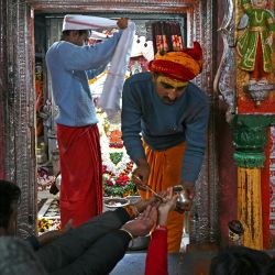 Un sacerdote distribuye agua bendita a los devotos en el templo del dios hindú Hanuman, en Ayodhya, India. | Foto:ARUN SANKAR / AFP