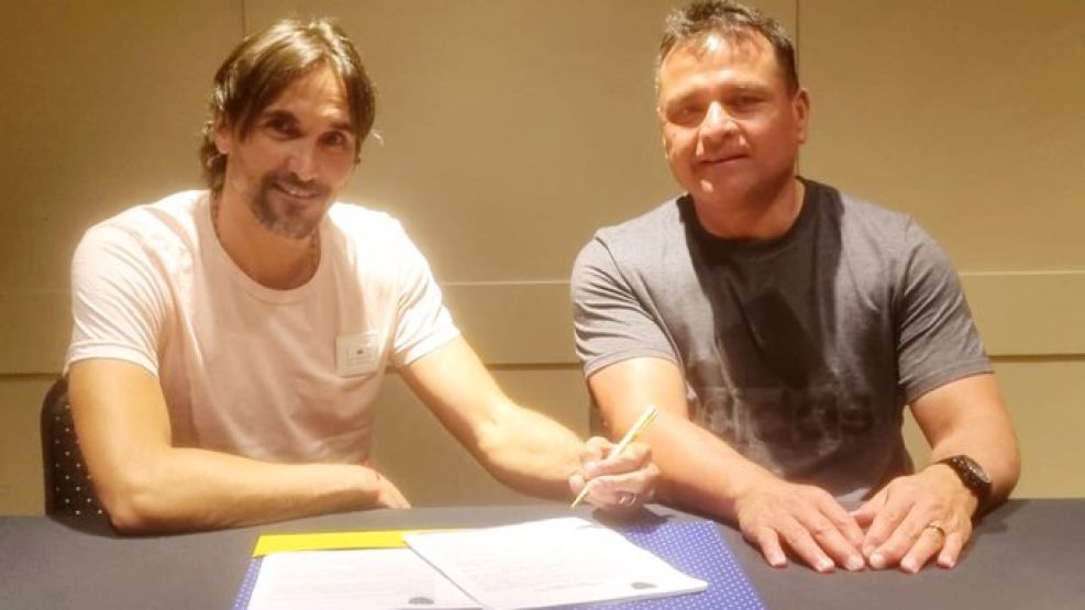 Diego Martínez, firmando su contrato con Boca, junto al Chelo Delgado.