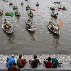 Los pescadores se sientan en un muelle junto a sus barcos durante las vacaciones de Año Nuevo en Surabaya, Indonesia. | Foto:Juni Kriswanto / AFP