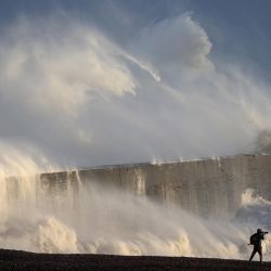 Una persona toma fotografías del mar mientras las olas rompen contra el rompeolas en Newhaven, cuando la tormenta Henk traería fuertes vientos y fuertes lluvias en gran parte del sur de Inglaterra. | Foto:ADRIAN DENNIS / AFP