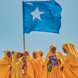 Los estudiantes ondean una bandera somalí durante una manifestación en apoyo del gobierno de Somalia tras el acuerdo portuario firmado entre Etiopía y la región separatista de Somalilandia en el estadio Eng Yariisow en Mogadiscio. | Foto:ABDISHUKRI HAYBE / AFP