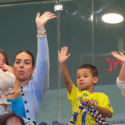 La esposa del delantero portugués Cristiano Ronaldo, Georgina Rodríguez, y sus hijos saludan antes del partido de fútbol de la Saudi Pro League entre Al-Nassr y Al-Riyadh en el estadio al-Awwal Park de Riad. | Foto:Fayez Nureldine / AFP