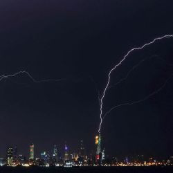Un rayo cae sobre la torre al-Hamra (derecha) y la torre de la Liberación (izquierda) en la ciudad de Kuwait durante una tormenta. | Foto:YASSER AL-ZAYYAT / AFP
