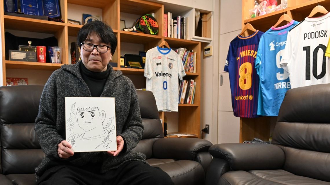  This photo taken on January 30, 2023 shows Japanese cartoonist and manga artist Yoichi Takahashi, best known for his work 'Captain Tsubasa', displaying his autograph with a painting of the main character following an interview with AFP at his workplace in Tokyo. 