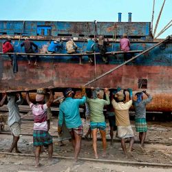 Los trabajadores de un astillero cargan una lámina de metal mientras reparan un viejo barco en un astillero a orillas del río Buriganga en Dhaka. Foto de Indranil MUKHERJEE / AFP  | Foto:AFP